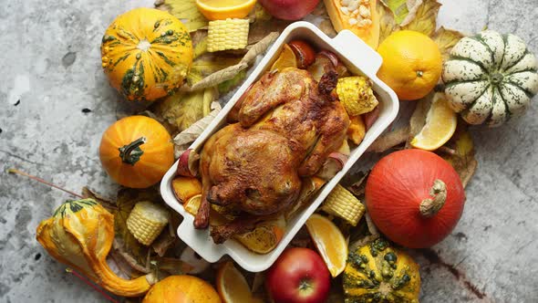 Roasted Turkey or Chicken with Thyme Served on Black Baking Dish with Potatoes Pumpkins