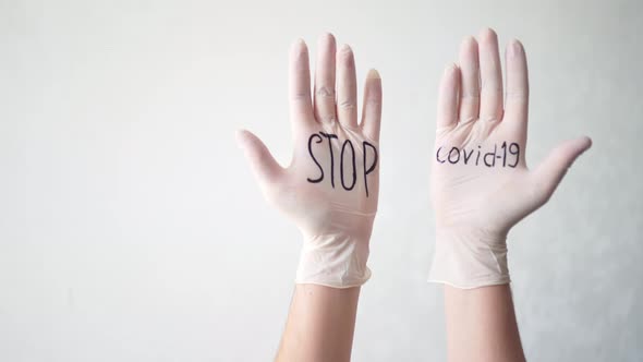 Stop Covid-19 Text on White Medical Gloves. A Protective Agent Against Coronavirus During a Pandemic