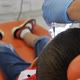 a Pediatric Dentist Grinds a Filling in the Mouth of a Teenage Patient Sitting in an Orange Dental - VideoHive Item for Sale