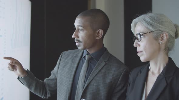 Two Finance Experts Discussing Stock Market Statistics alt