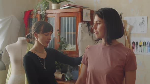 Seamstress Taking Body Measurements of Female Client in Atelier alt