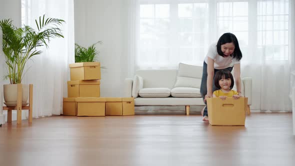 asian family playing with a box.Together having fun inside the house.family relationship alt