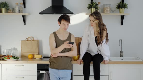Happy Couple Browsing Internet Together in the Morning Kitchen