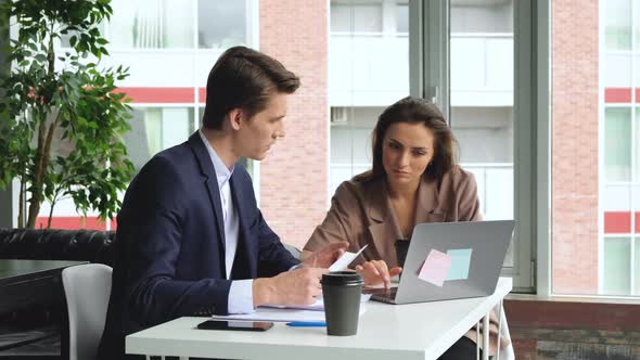 Man and woman work in modern office sitting at the table. Man and woman work alt