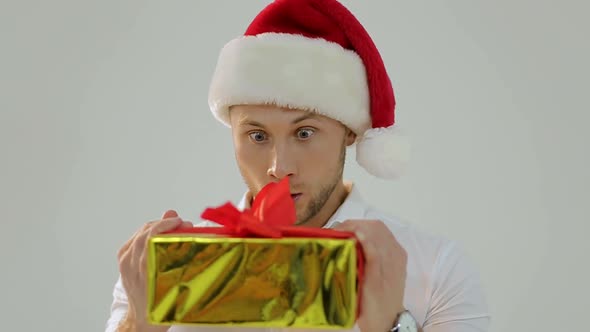 Portrait of a beautiful man in Santa's hat with a fun face image, white background alt