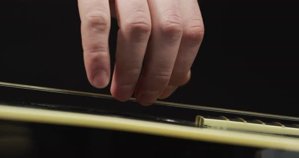Extreme close up of fingers strumming the strings alt