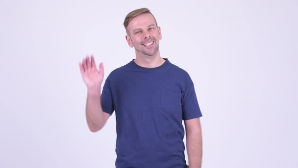 Portrait of Happy Blonde Man Smiling and Waving Hand alt