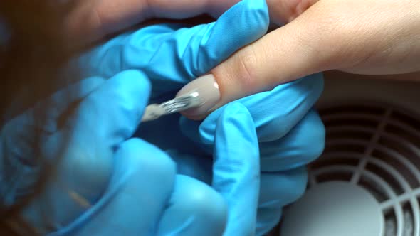 Close up footage of manicure artist making nail polishing with brush and tools	 alt
