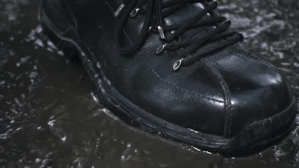 Black New And Glossy Boots Step On A Puddle. Slow Mo 3