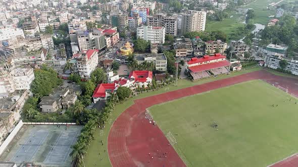 Epic drone shot above big city and indian soccer stadium,birds eye view alt