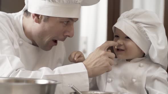 Lovely Closeup of Dad and Son Playing with Cake Batter