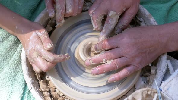 Top View on Potter's Hands Work with Clay on a Potter's Wheel. Slow Motion alt