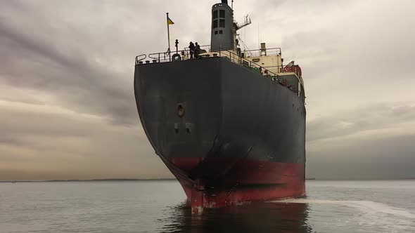 Low Angle Cargo Bulker Anchored Ukrainian Flag on Front of Ship and Sailors alt