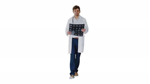 Concentrated Male Doctor Examining Computed Tomography While Walking on White Background