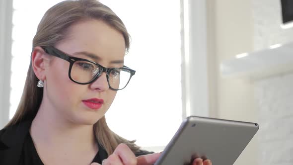 A Young Female Business Entrepreneur Presses And Swipes Across Her Tablet 1