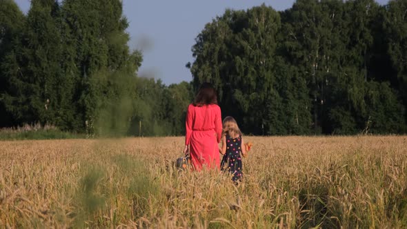 Little Girl with Mother Walking Through a Field alt