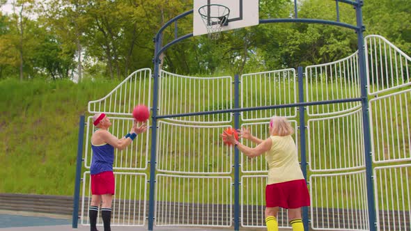 Senior Old Basketball Team Man and Woman Playing Game Throwing Ball Into Basket at Stadium Court alt