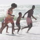 Smiling african american family holding hands and running on sunny beach - VideoHive Item for Sale