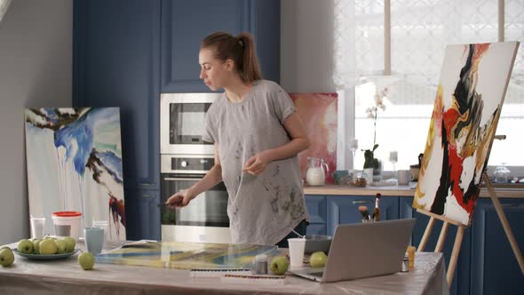 Young Woman Having Lunch and Taking Picture of Painting alt