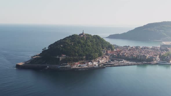 San Sebastian cityscape and island with tower in Atlantic ocean, aerial drone alt