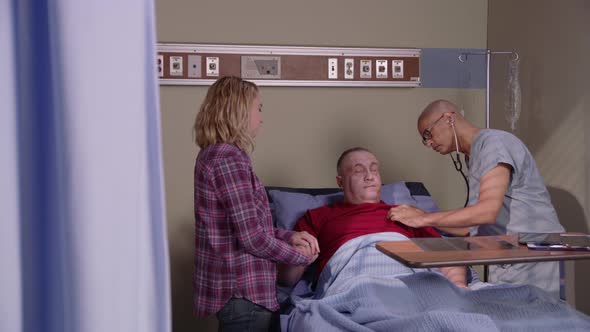 Senor man gets hospital check up with daughter holding hand