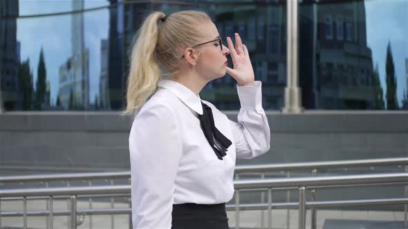 stylish business woman walks past a glass building