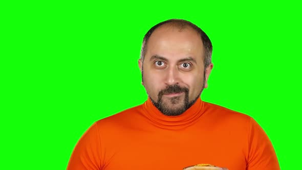 Man with Overweight Is Played with Burgers, Green Screen. Slow Motion alt