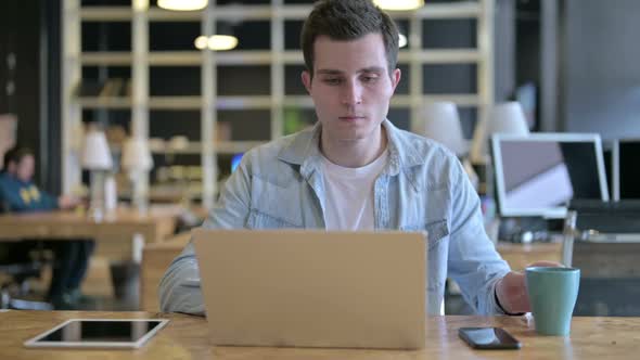 Hardworking Young Designer Drinking Coffee in Modern Office alt