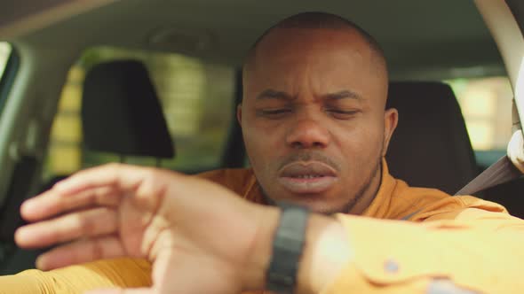 Male Driver Checking Time at Wristwatch in Rush Hours alt