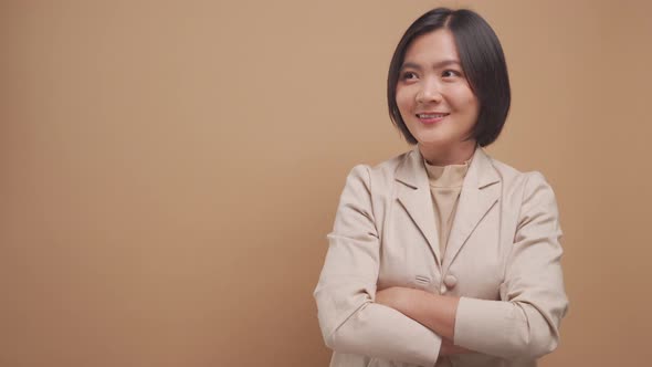 Confident asian business woman happy standing and pointing to copy space isolated