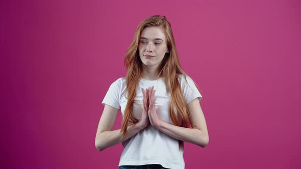 The Young Redhead Rubs Her Palms Conspiratorially and Looks to One Side alt
