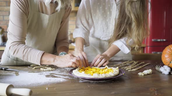 Aged Lady and Young Woman Prepare Pumpkin Pie Fixing Dough