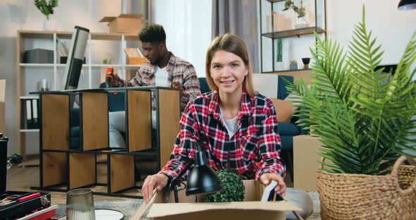 Girl Looking Into Camera with Thumb Up on the Background of Likable Skilful Black-Skinned Boyfriend alt