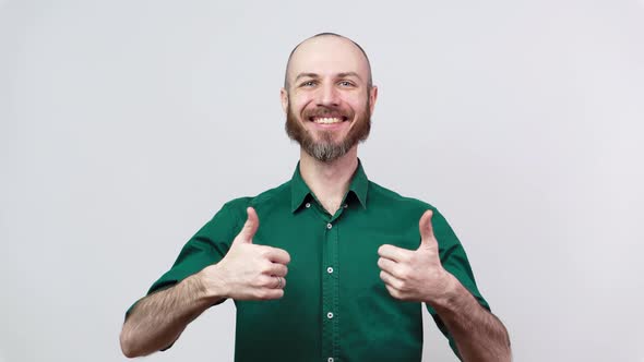 Happy bearded man showing thumbs up sign over white background. Good job.