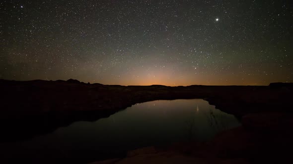 Time lapse of the moon rising over lake in the desert alt