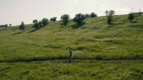 Runner Running in the Field. Aerial Drone Footage.