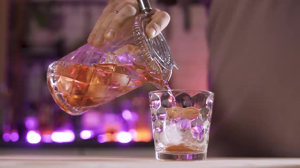 Bartender Mixologist Pouring Cocktail Using Strainer