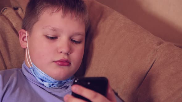 Happy Boy Browses Social Networks on a Smartphone Plays Mobile Games alt