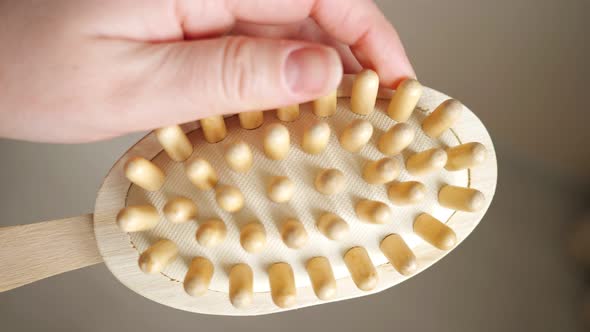 Closeup of a Woman's Hand Holding a Lymphatic Drainage Brush alt