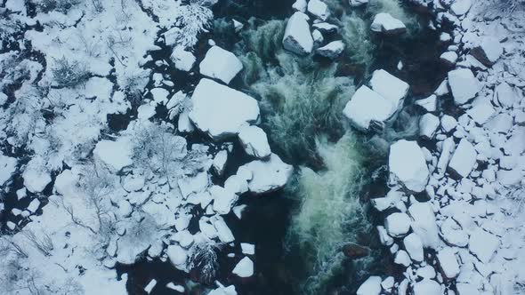 River flows in ice. Aerial top down view of the river flowing among the ice.	