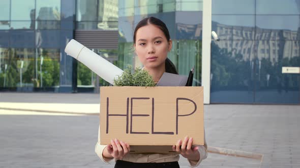 Unemployed Asian Female Holding Cardboard Box With Word Help Outside alt