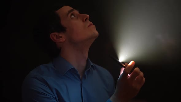 Man Uses Flashlight on Smartphone alt