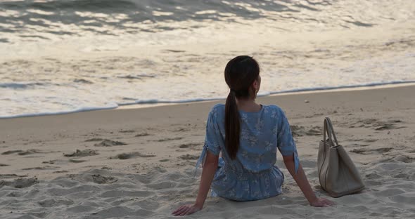 Woman stand on the beach and enjoy the view of the sea at sunset time alt