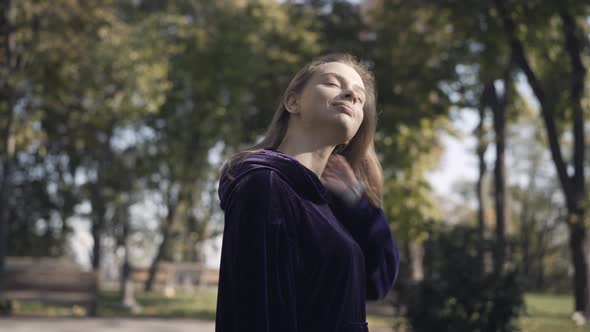 Side View of Smiling Gorgeous Sportswoman Shaking Hair in Sunlight Outdoors alt