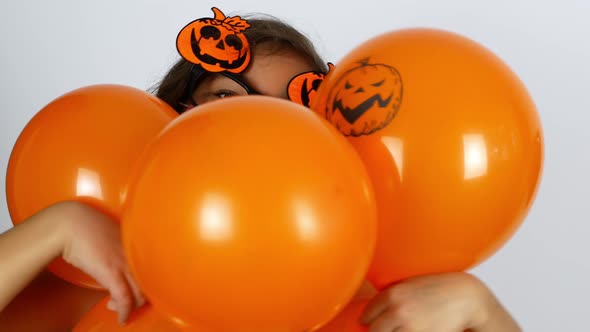 Halloween A little girl in a mask and a festive outfit is getting ready for Halloween. alt