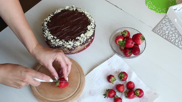 A Woman Cuts A Strawberry. For Cake Decorating. alt