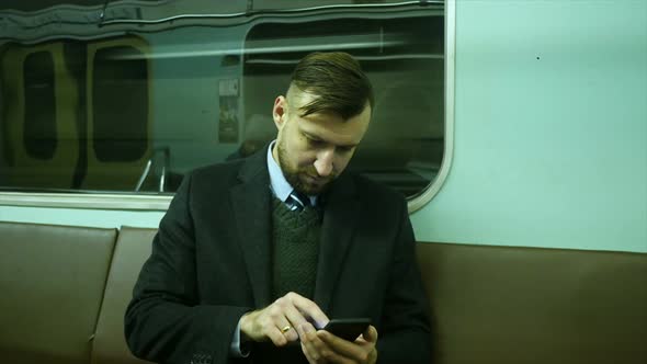 A Serious Man in Metro Looks at Phone