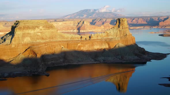 Boat moving across Lake Powell viewing a reflection of the landscape alt
