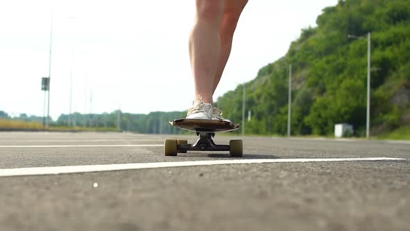 Young Girl Learns To Ride on a Longboard. Slow Motion
