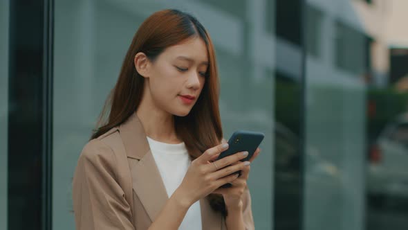 Asian Businesswoman using a mobile phone. Asian successful businessperson looking at smartphone